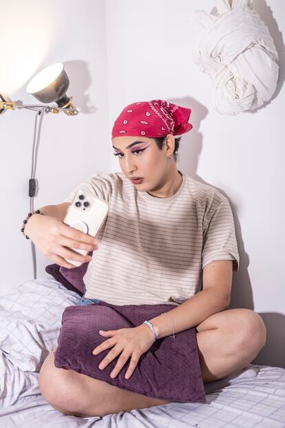 Alejandro Orellana, haciéndose un selfie después de maquillarse, en el interior de su habitación en el barrio de Usera.