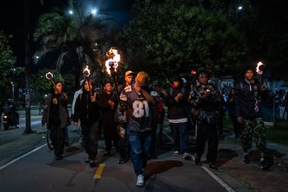 Jóvenes de Bosa caminan con antorchas durante la velatón por el asesinato de los líderes sociales Camilo Sanchéz ‘MC CUB’ y Camilia Ospitia, en el barrio El Porvenir, en Bosa, el 16 de agosto de 2024.