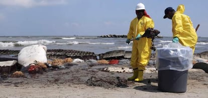 Unos operarios limpian de crudo la playa Port Fourchon, en Louisiana