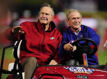Los expresidentes de EE UU George H. W. Bush (izquierda) y George W. Bush, padre e hijo, llegan a la ceremonia del cuarto partido de la Serie Mundial de Béisbol celebrada en el campo de los Rangers, en Arlington (Texas), el 31 de octubre de 2010.
