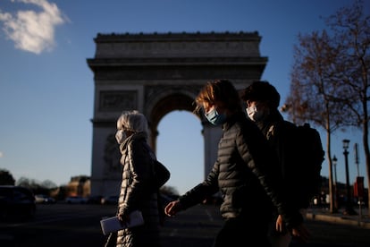 Pedestres caminham pela Champs Elysees, em Paris, com máscaras de proteção contra a covid-19, nesta segunda-feira, 25 de janeiro. Europa cobra transparência das farmacêuticas sobre vacinas.