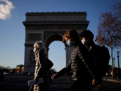 Pedestres caminham pela Champs Elysees, em Paris, com máscaras de proteção contra a covid-19, nesta segunda-feira, 25 de janeiro. Europa cobra transparência das farmacêuticas sobre vacinas.