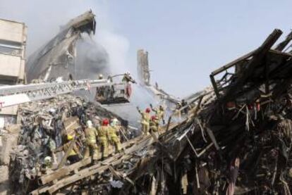 Miembros de los servicios de rescate iraníes buscan posibles víctimas entre los escombros del edificio Plasco.
