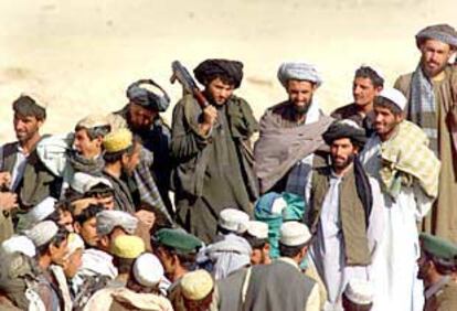 Un combatiente talibán armado, entre un grupo de refugiados afganos en una zona fronteriza con Pakistán, cerca de Chamán.