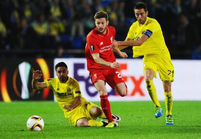  Adam Lallana (i) del Liverpool y Bruno del Villarreal intentan hacerse con el balón.