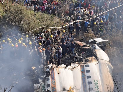 Nepalese rescue workers and civilians gather around the wreckage of a passenger plane that crashed in Pokhara, Nepal, Sunday, Jan. 15, 2023.