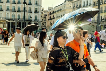 Turistas pasean bajo altas temperaturas por el centro de Madrid, el domingo.