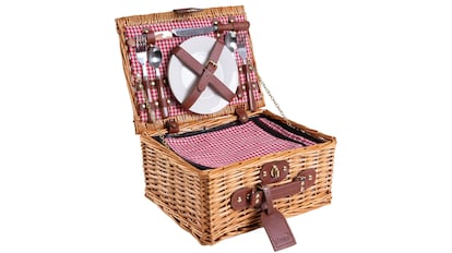 Esta cesta de pícnic está elaborada con mimbre y se cierra mediante una serie de correas de cuero.