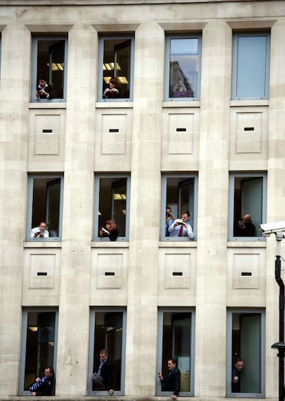 Trabajadores del edificio de oficinas de la calle Fleet fotografían el féretro con los restos mortales de la ex primer ministra británica Margaret Thatcher durante el cortejo fúnebre por las calles de Londres.