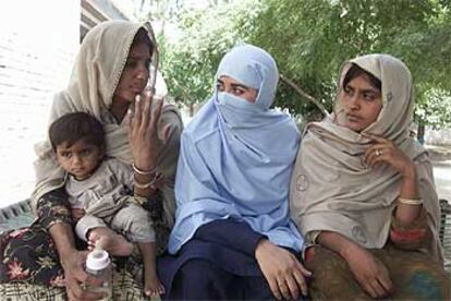 Las dos mujeres violadas por una "cuestión de honor" hablan con una policía (en el centro) ante la comisaría de Multan.