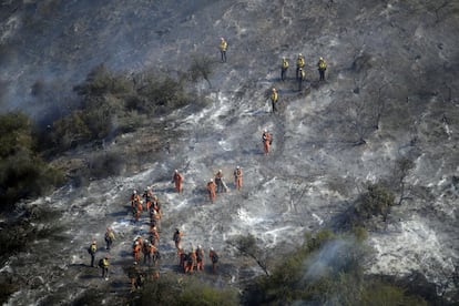 Equipes de trabalho em uma encosta afetada pelos incêndios florestais em Mandeville Canyon na segunda-feira, em Los Angeles. A tática do blecaute para evitar incêndios, aceitável quando aplicada cirúrgica e ocasionalmente, desencadeou a indignação quando aplicada massivamente e com pouco tempo para se preparar. A empresa estatal de energia recebeu críticas severas de políticos do estado, mas a realidade é que eles não podem fazer nada a respeito.