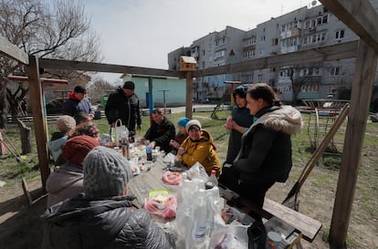 Lugareños almuerzan fuera de un edificio residencial dañado en Makariv, cerca de Kiev, el pasado 14 de abril.