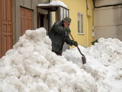 Un hombre retira la nieve de la puerta de su casa en la localidad de Pedrafita do Cebreiro, en Lugo. Aunque la normalidad regresa poco a poco a la Montaña de Lugo, el 30 de octubre de 2018.