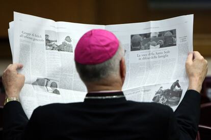 Un obispo lee el periódico 'L'Osservatore Romano' en el cuarto día del sínodo sobre temas de familia, en el Vaticano.