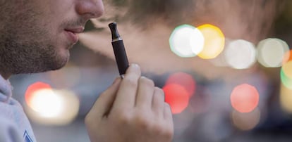Un hombre fuma un cigarrillo electrónico.