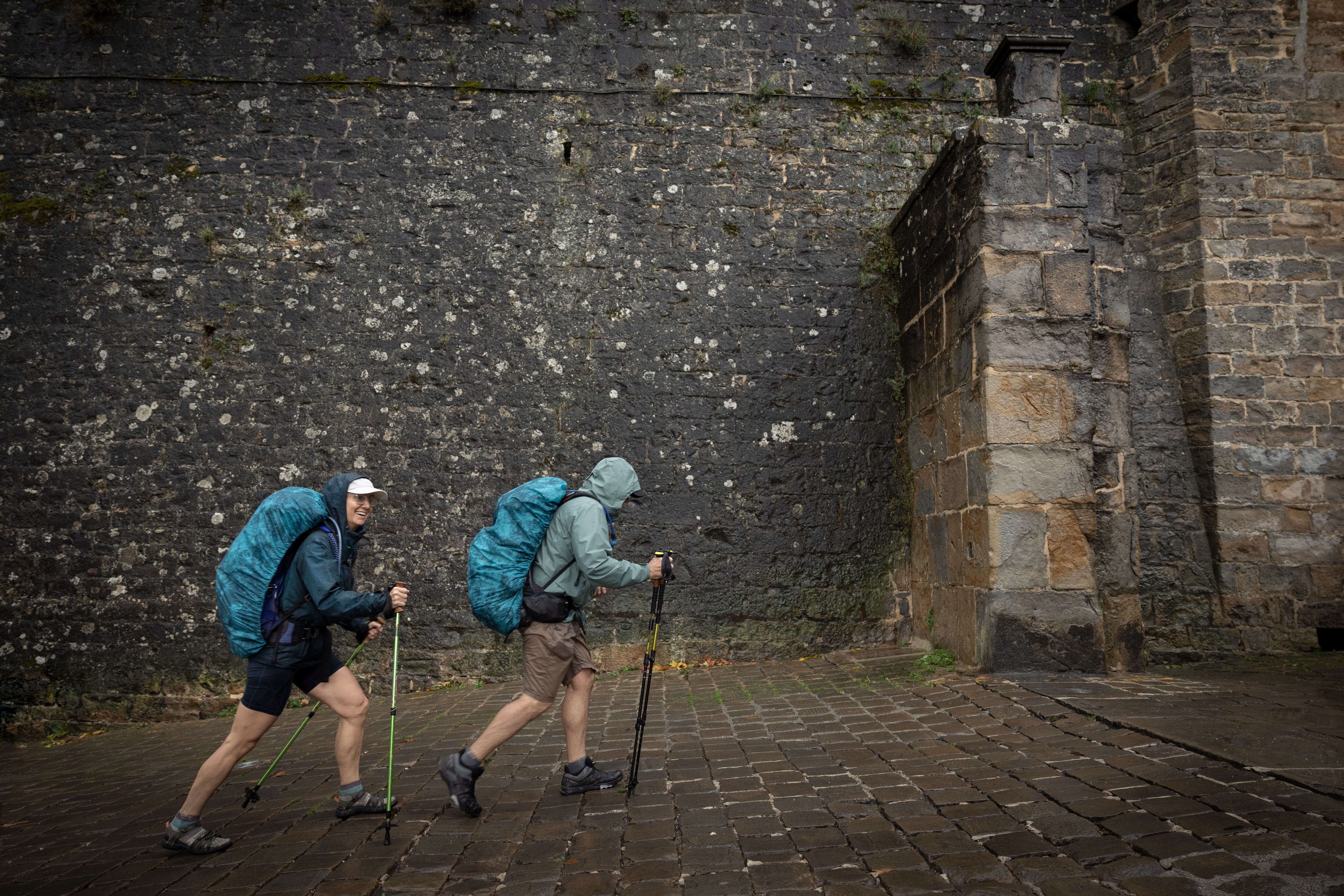 Dos peregrinos que realizan el Camino de Santiago llegan a Pamplona, el sábado.