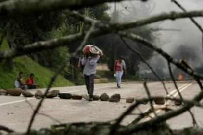 Un grupo de personas cruza una vía bloqueada en la vía Panamericana, en el suroccidente de Colombia, el pasado 27 de febrero. EFE/Archivo