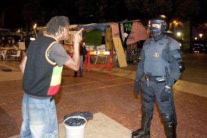 Un acampado se encara con un mosso, anoche en la plaza de Catalunya.