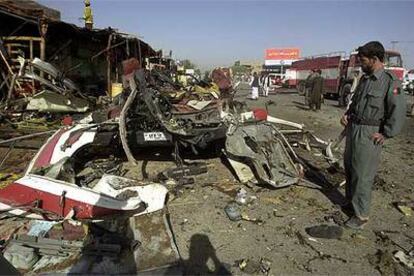 Un miembro de las fuerzas de seguridad afganas mira los restos del autobús atacado en Kandahar.