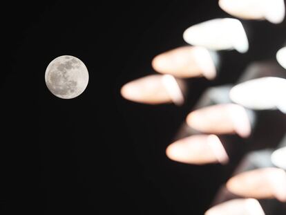La luna se ve a través de las luces en Catar, la noche del 11 de diciembre.