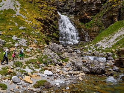 Tres excursionistas llegando a la cascada Cola de Caballo, en el parque nacional de Ordesa y Monte Perdido.