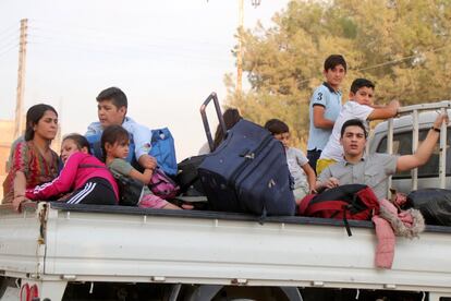 Familias kurdas huyen en una camioneta de la localidad de Ras al-Ein (norte de Siria), tras el inicio de la ofensiva turca.