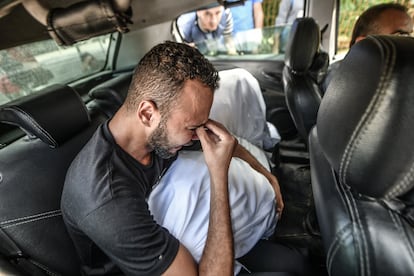 Un hombre llora en el interior de un coche mientras la gente asiste a la ceremonia fúnebre de los periodistas palestinos Said al Taweel y Mohammed Sobboh, muertos en un ataque aéreo israelí, en Jan Yunis, en la franja de Gaza. 