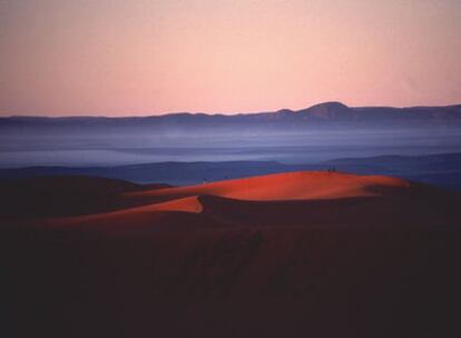 Amanecer en las dunas de Merzouga, al sur de Marruecos; al fondo, la cordillera del Atlas