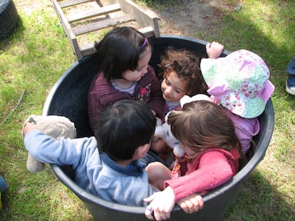 Un grupo de niños juega a encajarse en un cubo en el espacio educativo La Violeta, en Galapagar, Madrid.