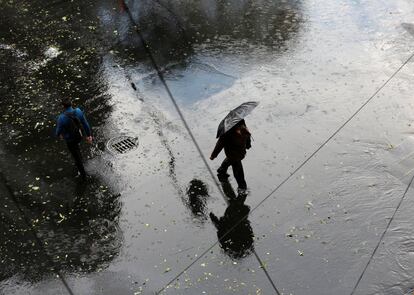 Un hombre camina bajo la lluvia en Ciudad de México.