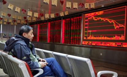 Un hombre observa un panel de información bursátil en Pekín (China).