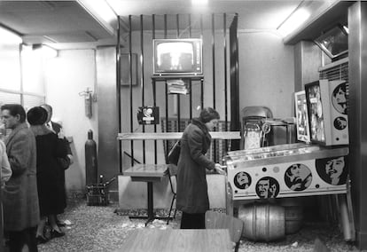 Una mujer juega en la máquina recreativa de un bar, en 1973.