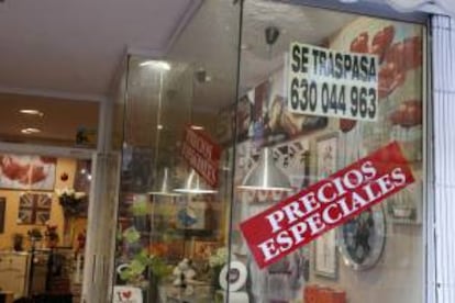 Un cartel ofrece precios especiales en el escaparate de una tienda de muebles y decoración que se traspasa. EFE/Archivo