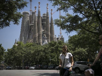 Varios viandantes, con la Sagrada Familia al fondo.