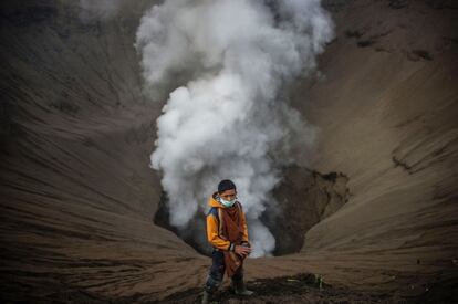 Un niño indonesio se prepara para coger las ofrendas lanzadas por los devotos hindúes de la tribu Tengger durante el Yadnya Kasada Festival, en el cráter del monte Bromo en Probolinggo, Indonesia. 