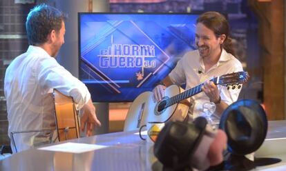 Pablo Motos, de espaldas, y Pablo Iglesias, tocando la guitarra en &lsquo;El Hormiguero&rsquo;. 