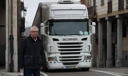 Jesús María Lorenzo Mas, alcalde de Alcañices, junto a un camión que pasa por la N-122, una carretera que divide el pueblo en dos. Cada día "800 camiones" pasan por esta vía, se queja él.