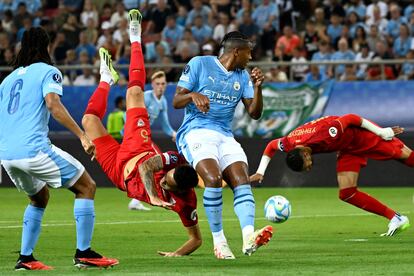 El delantero argentino del Sevilla Lucas Ocampos intenta una chilena junto al defensa suizo del Manchester City Manuel Akanji.