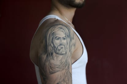 Ali, de 22 años, posa para una foto mostrando su tatuaje del primer Imam chiíta, Ali, en el suburbio del sur de Beirut, Líbano.