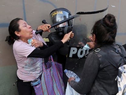 Mujeres manifestantes pelean con un policía antidisturbios durante una protesta que exige la disolución del Congreso y la celebración de elecciones democráticas en Perú.