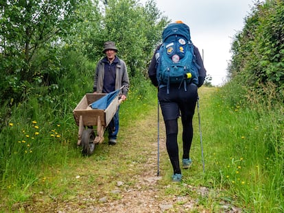 Una peregrina del Camino de Santiago se cruzaba en mayo con un granjero, en Pola de Allande (Asturias).