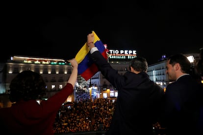 La presidenta de Madrid, Isabel Díaz Ayuso, y el líder venezolano Juan Guaidó, sostienen una bandera de Venezuela ante cientos de personas en la Puerta del Sol, acompañados por el entonces vicepresidente Ignacio Aguado.