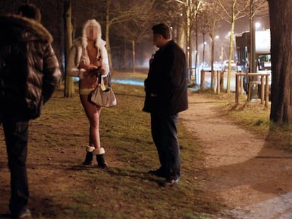 Dos agentes interrogan a una prostituta y a un cliente durante una operaci&oacute;n policial en Par&iacute;s en marzo de 2012.