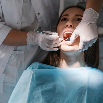 Lithuania, Vilnius, Dentist examining mouth of patient using tools