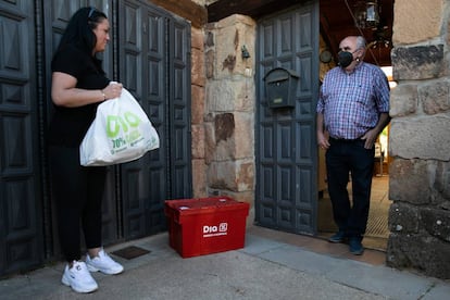 Alejandro recibe su compra en la puerta de su casa de manos de Victoria.