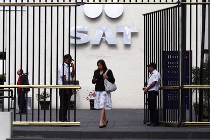 Una mujer sale de las oficinas del Sistema de Administración Tributaria.