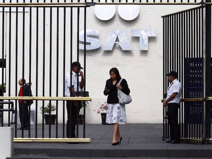 Una mujer sale de las oficinas del Sistema de Administraci&oacute;n Tributaria.