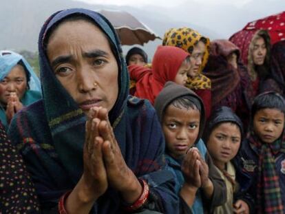 Aldeanos piden alimento tras aterrizar un helicóptero de ayuda en Gumda, distrito de Gorkha (Nepal).