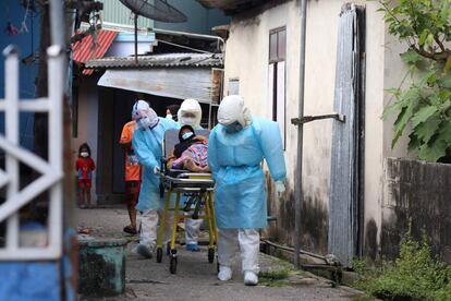 Trabajadores sanitarios trasladan a un paciente con coronavirus al hospital desde una aldea en Pattani (Tailandia). El Gobierno de este país ha constatado 11.784 casos en el último día, lo que supone el cuarto consecutivo con cifras récord de contagios.