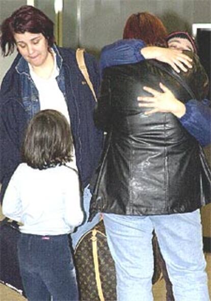 El niño secuestrado abraza a un familiar, ayer, a su llegada al aeropuerto de Biarrtiz (Francia). A la izquierda, Inés Nieto.